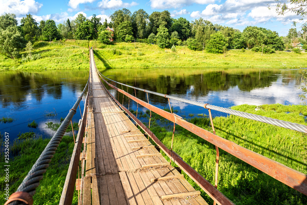 Fototapeta premium Suspension bridge across the Msta river in Borovichi, Russia