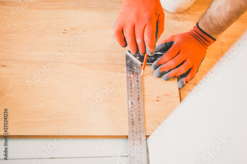 The builder is engaged in laying laminate in the room - repair and finishing work