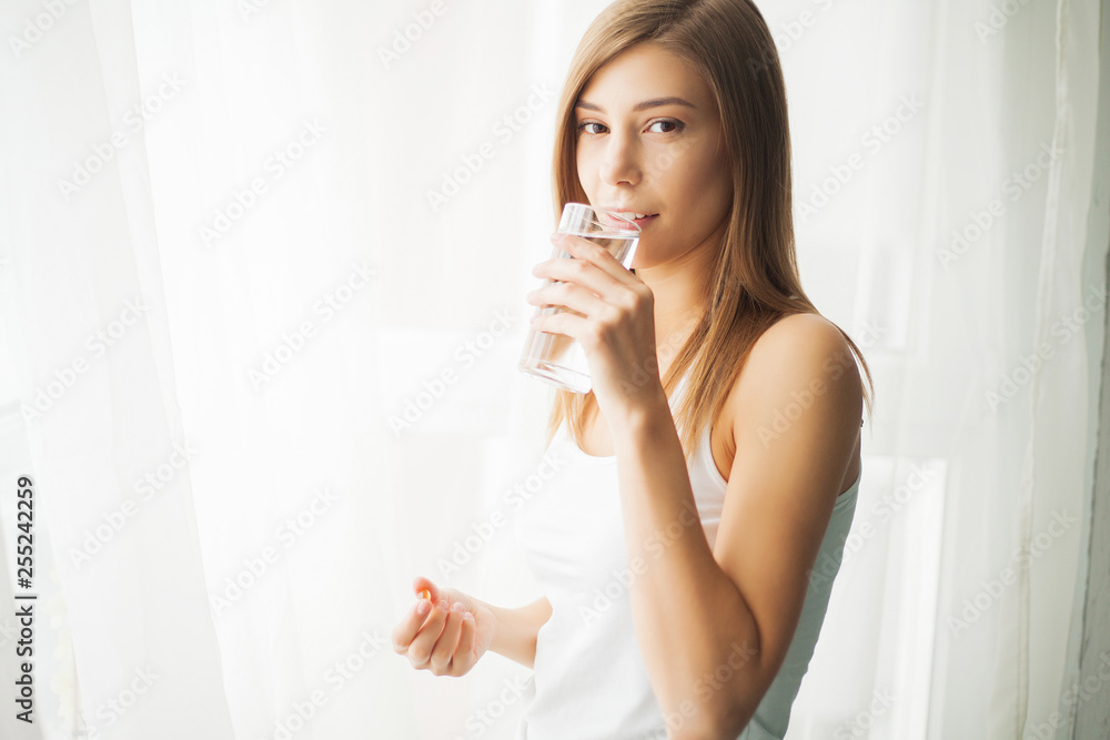 Health concept. Young woman holding pill and glass of water Health concept. Young woman holding pill and glass of water