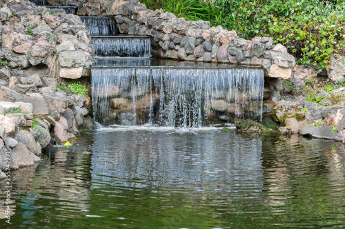 Landscape of small waterfall in the city park.