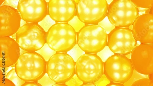 Bright yellow hydrogel balls closeup, rotation
