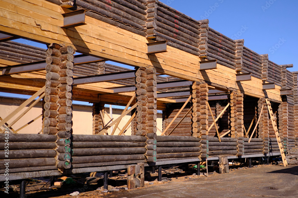 New wooden blockhouse. Construction of a house or dwelling. Walls of round treated pine trunks. The angle of the structure. The method of laying New wooden blockhouse. Construction of a house or dwelling. Walls of round treated pine trunks. The angle of the structure. The method of laying