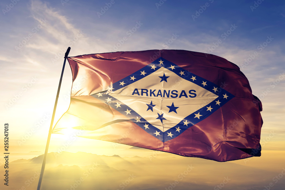 Arkansas state of United States flag waving on the top sunrise mist fog - obrazy, fototapety, plakaty 
