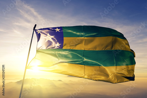 Sergipe state of Brazil flag waving on the top sunrise mist fog photo