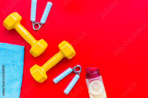 Fitness background with sport equipment for gym and home on red background top view copyspace