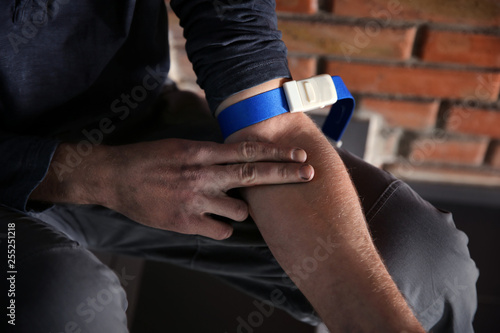 Male drug addict preparing his hand for injection  closeup