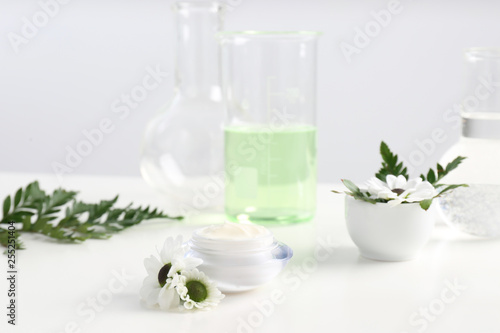 Skin care product  ingredients and laboratory glassware on table. Dermatology research