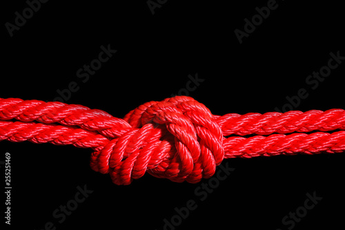 Red rope with knot on black background