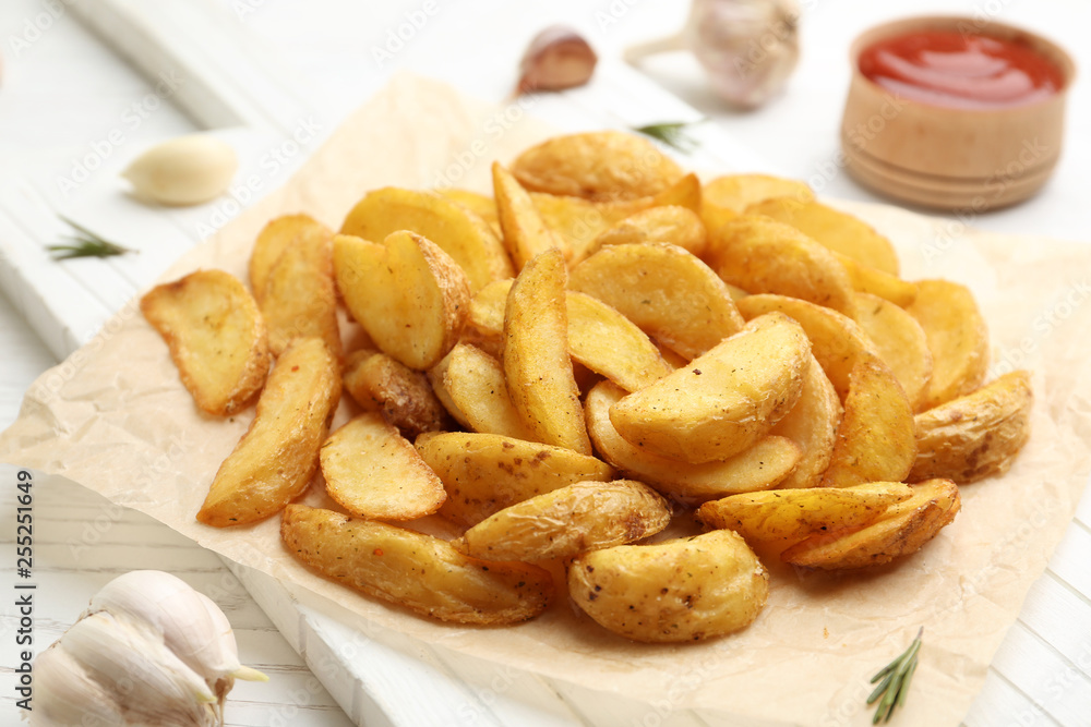 Delicious baked potato wedges on wooden table Delicious baked potato wedges on wooden table