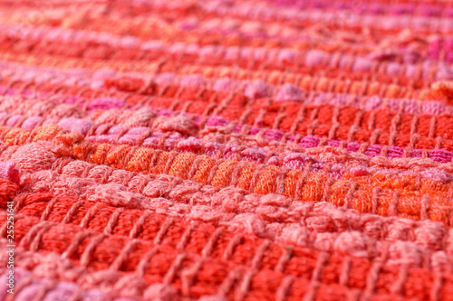 Texture of knitted orange and pink fabric as background, closeup