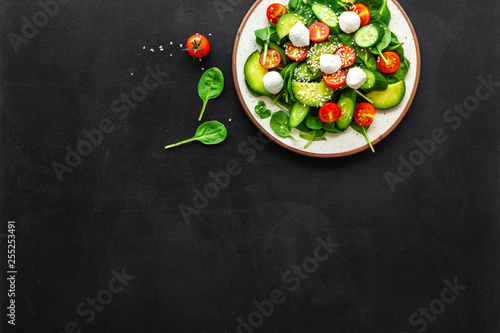Healthy lunch. Fresh vegetable salad on black background top view copy space