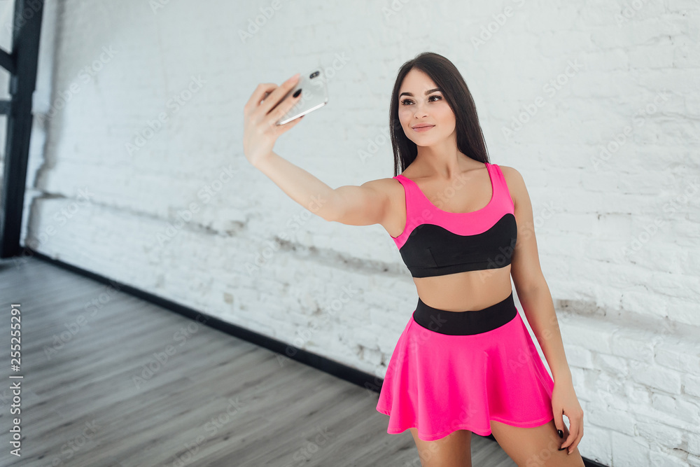 Yong attractive fitness woman making selfie isolated on white room. Yong attractive fitness woman making selfie isolated on white room.