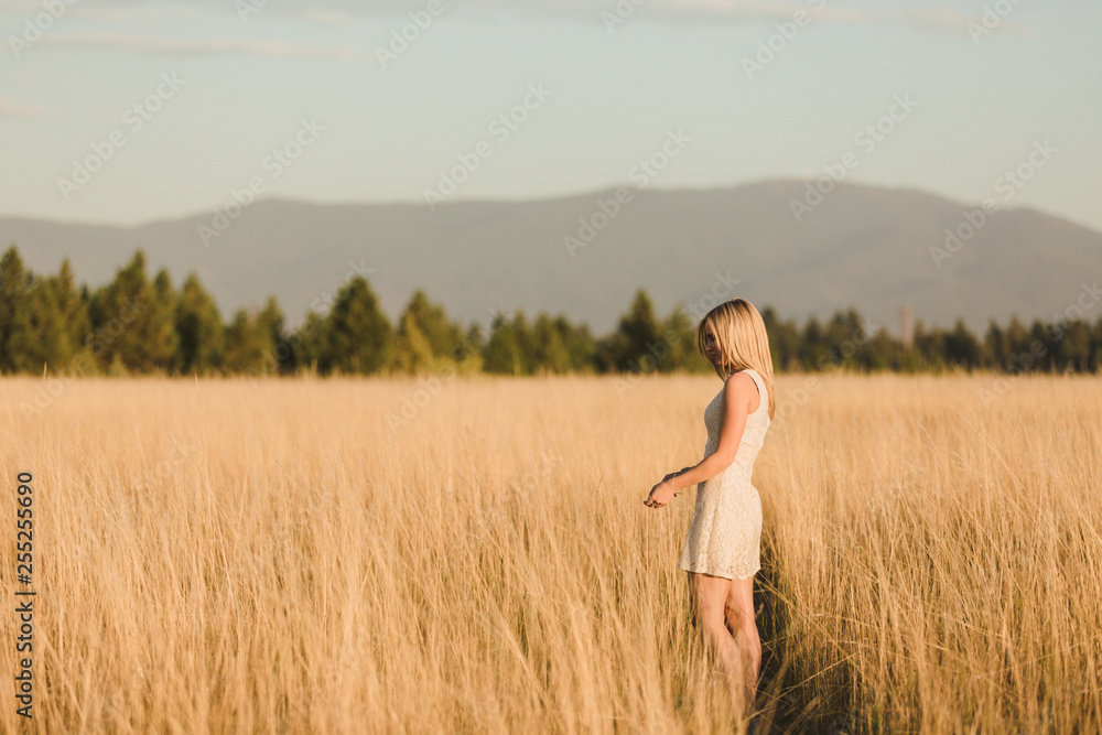 Young girl walking in tall grass field