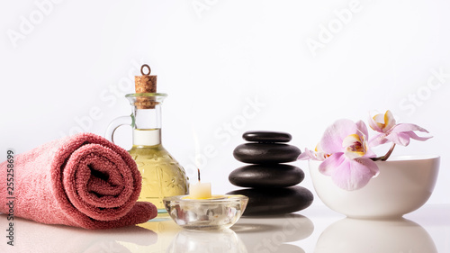 Spa still life composition. Spa stones, bottle with oil, candle ,orchid, towel.