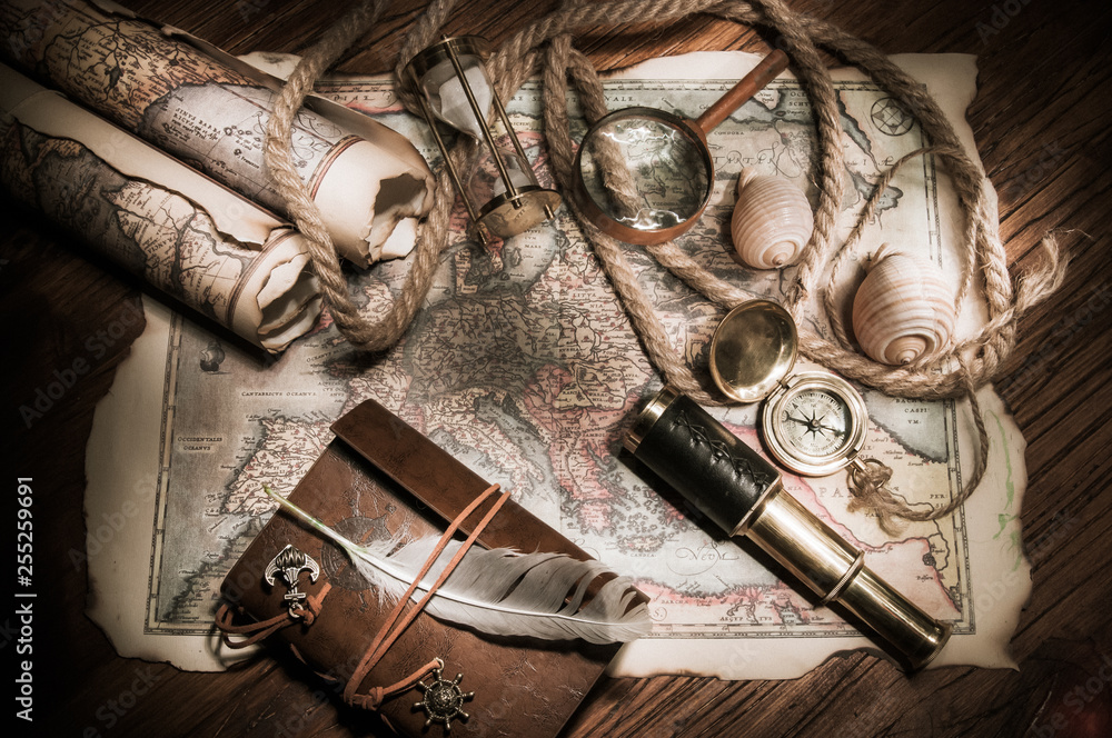 Old maps and vintage objects on a wooden table, high contrast effect