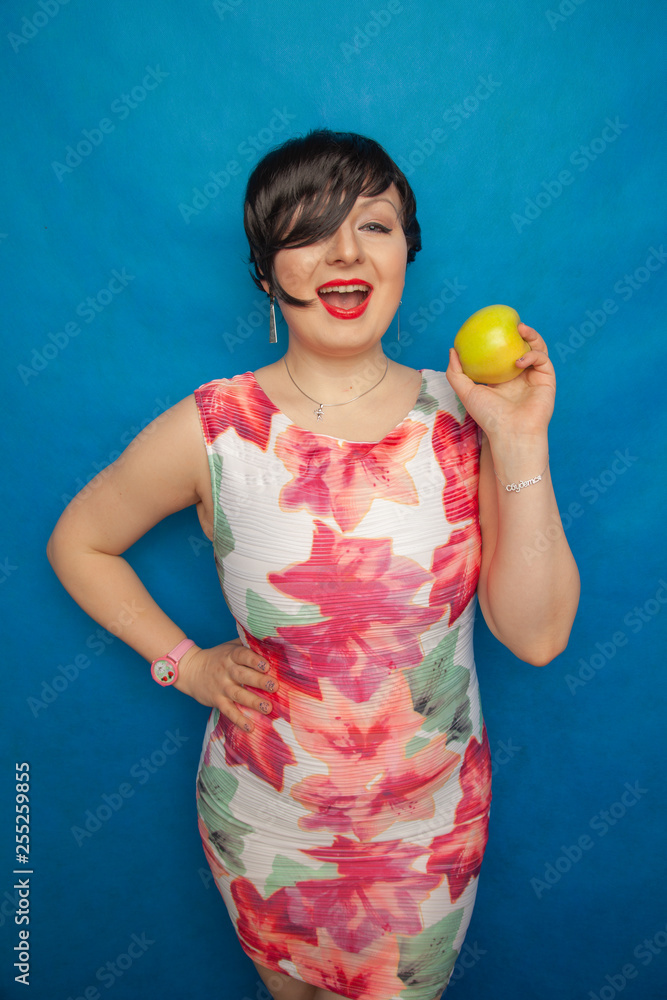 chubby plus size woman holding green apple on blus studio solid background chubby plus size woman holding green apple on blus studio solid background