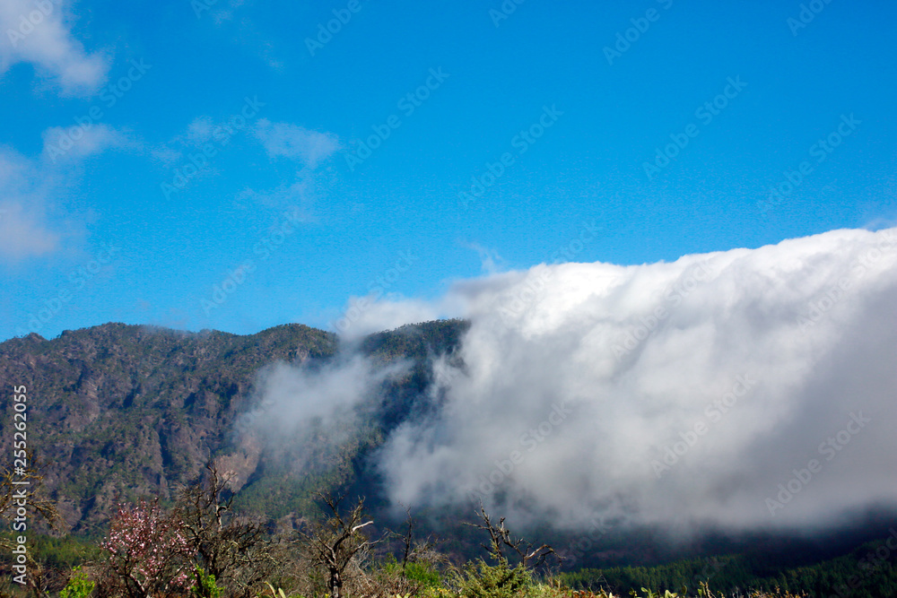Passatwolken wälzen sich über die Berge der Cumbre Vieja