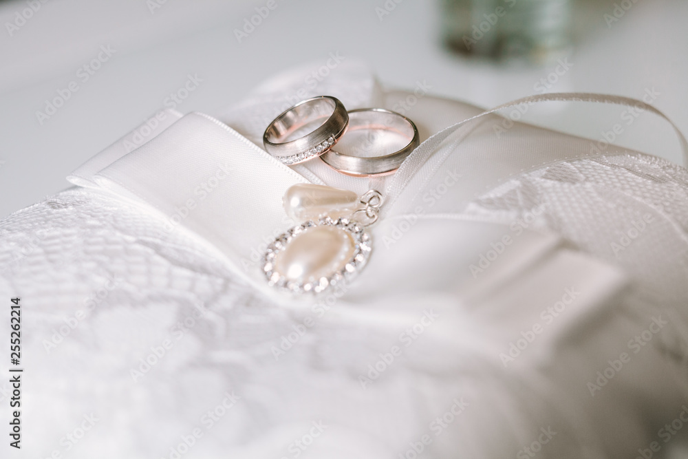 Golden wedding rings on white pillow Golden wedding rings on white pillow