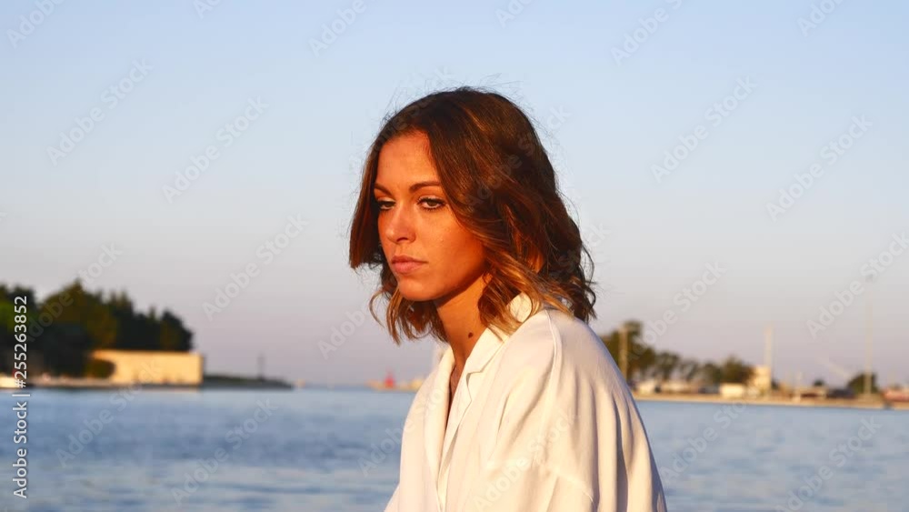 Pensive young woman face looking away at dawn outdoors. Close up profile portrait of beautiful girl with long wavy hair lonely, hopeful, thinking. On port background Pensive young woman face looking away at dawn outdoors. Close up profile portrait of beautiful girl with long wavy hair lonely, hopeful, thinking. On port background