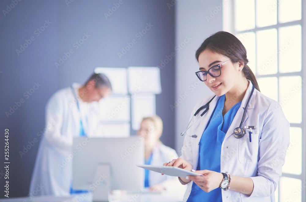 Female doctor using tablet computer in hospital lobby Female doctor using tablet computer in hospital lobby