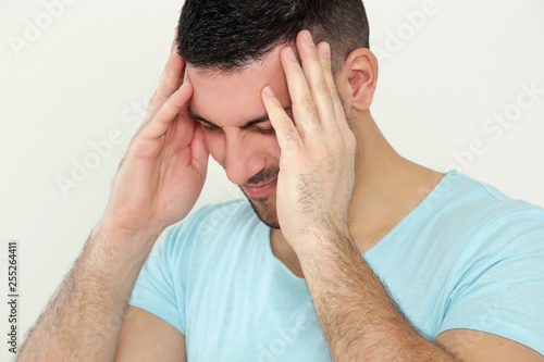 Young man with headache, portrait of worried young man