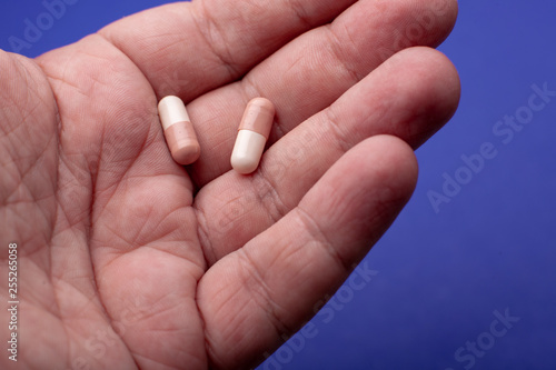 Close-up shot of a hand holding two pills