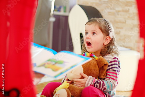 A happy family, the mother of her daughter reads books and stories in the house on the floor