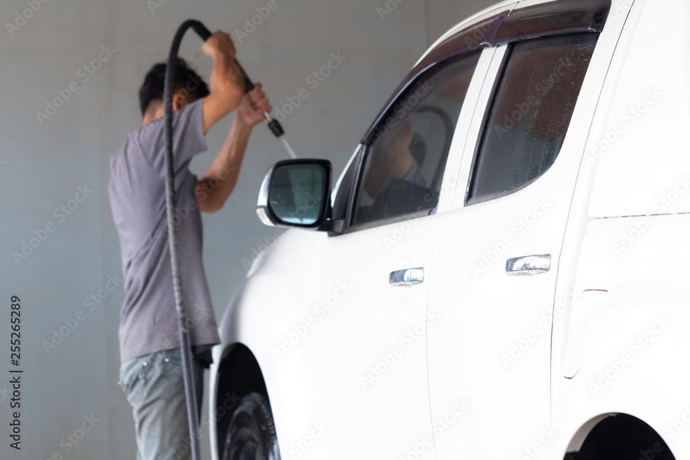 Employees worker washing car in the car wash shop.