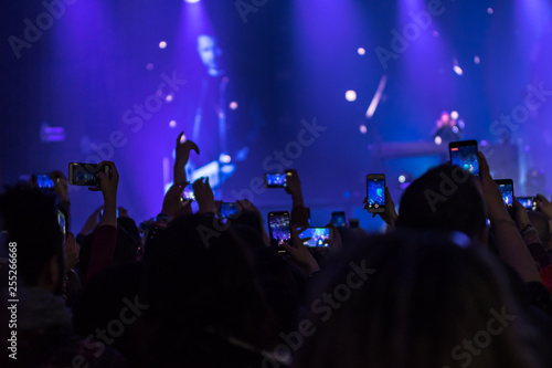 many people who dance and record with the phones at the live music concert © Giovanni Nitti