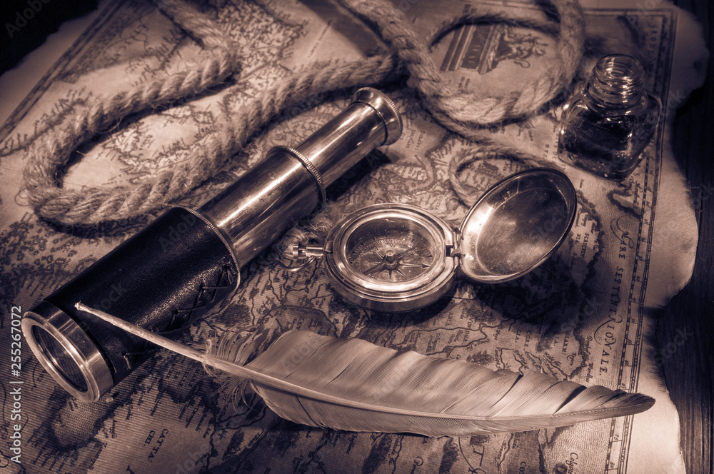 Old maps and vintage objects on a wooden table, sepia effect