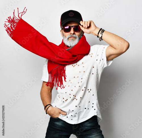 Foto Brutal senior rich man in white fashionable t-shirt cap and long red scarf styli
