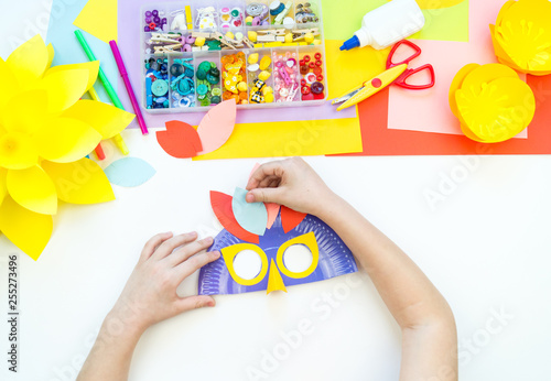 A child makes a bird mask out of paper. Master class crafts. Tropical Parrot.