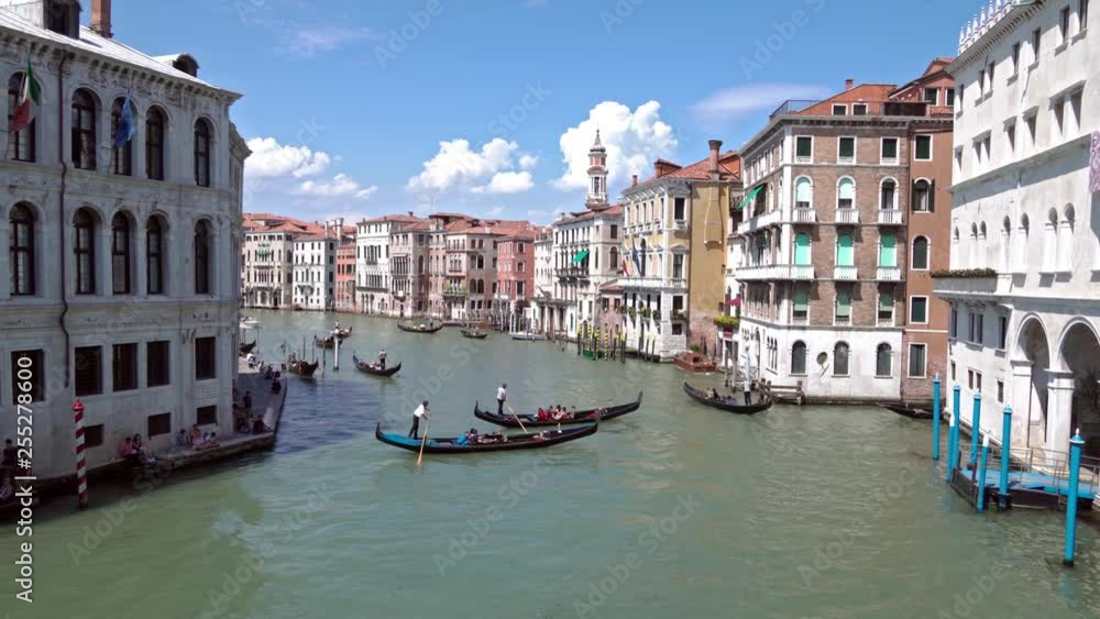 Scenic view of the Grand Canal with floating boats and gondolas from Rialto bridge in the center of Venice, Italia   on a sunny day