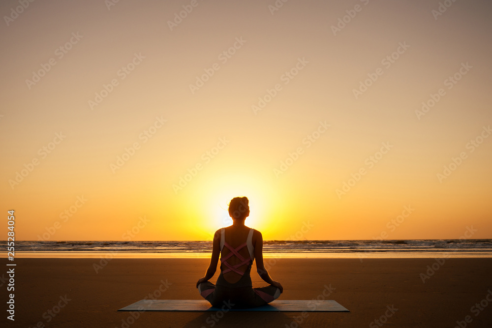 copyspace woman doing yoga performing asanas and enjoying life at sunset on the beach sea copy space