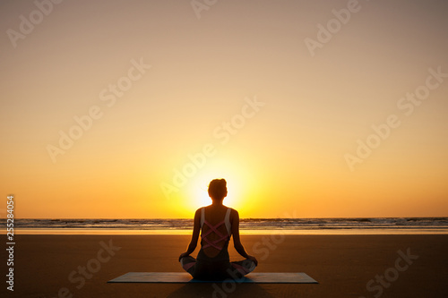 copyspace woman doing yoga performing asanas and enjoying life at sunset on the beach sea copy space