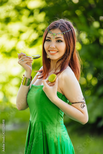 Beautiful young asian woman eating fresh kiwi