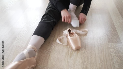 ballerina wearing ballet shoes before practicing, close up detail shooting, front view. 4k shooting