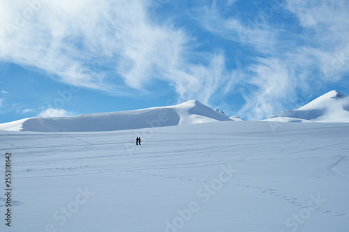 Image of a snow covered mountain plateau. Tourists walk and take pictures on a mountain plateau.