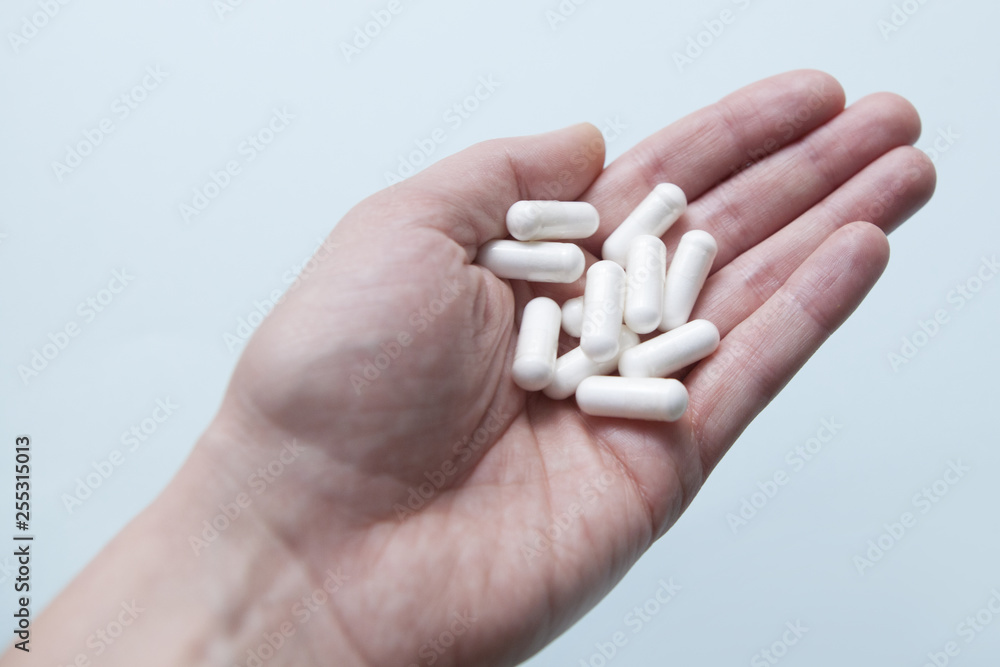 Pills in hand, capsule on a blue background Pills in hand, capsule on a blue background