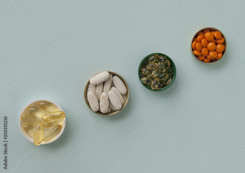 Pills, tablets and capsules and a bottle on a blue background. Copy space for text. Pills, tablets and capsules and a bottle on a blue background. Copy space for text.