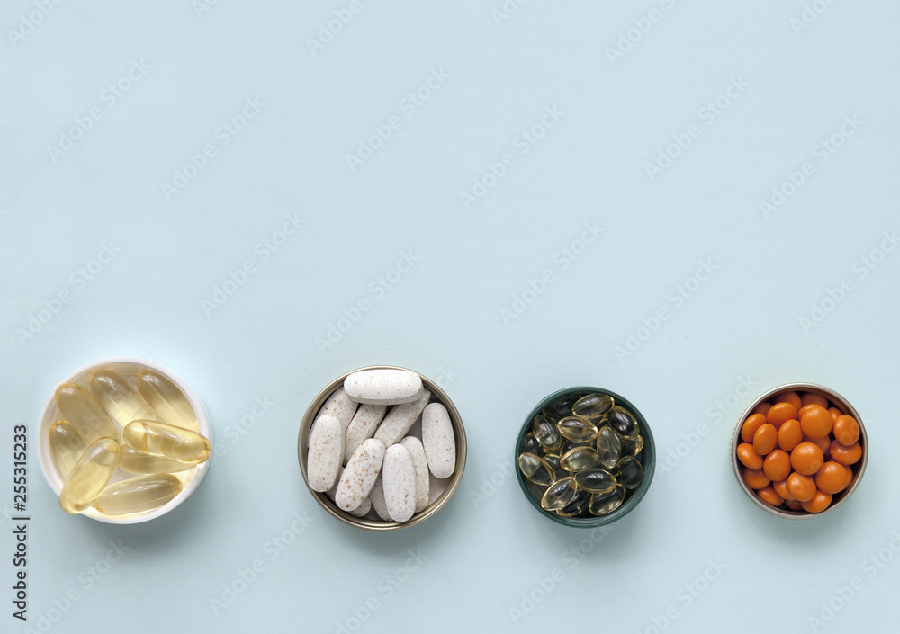 Pills, tablets and capsules and a bottle on a blue background. Copy space for text. Pills, tablets and capsules and a bottle on a blue background. Copy space for text.