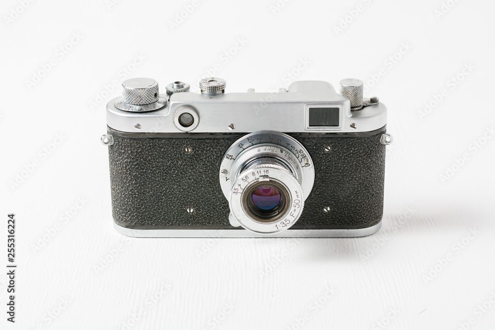 Old rangefinder vintage camera against white background with small lens. Range finder photo camera with lens. Classic black manual film camera.