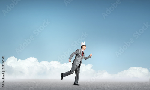 King businessman in elegant suit running and blue cityscape silhouette at background