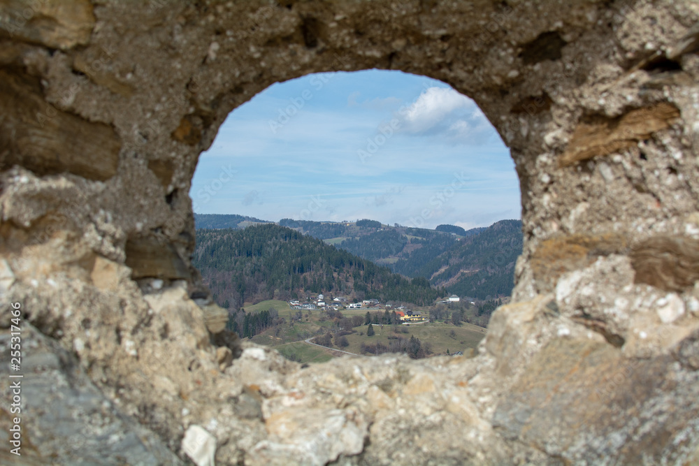a small town seen through a hole in an ancient wall