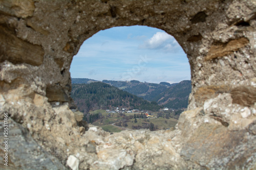 a small town seen through a hole in an ancient wall