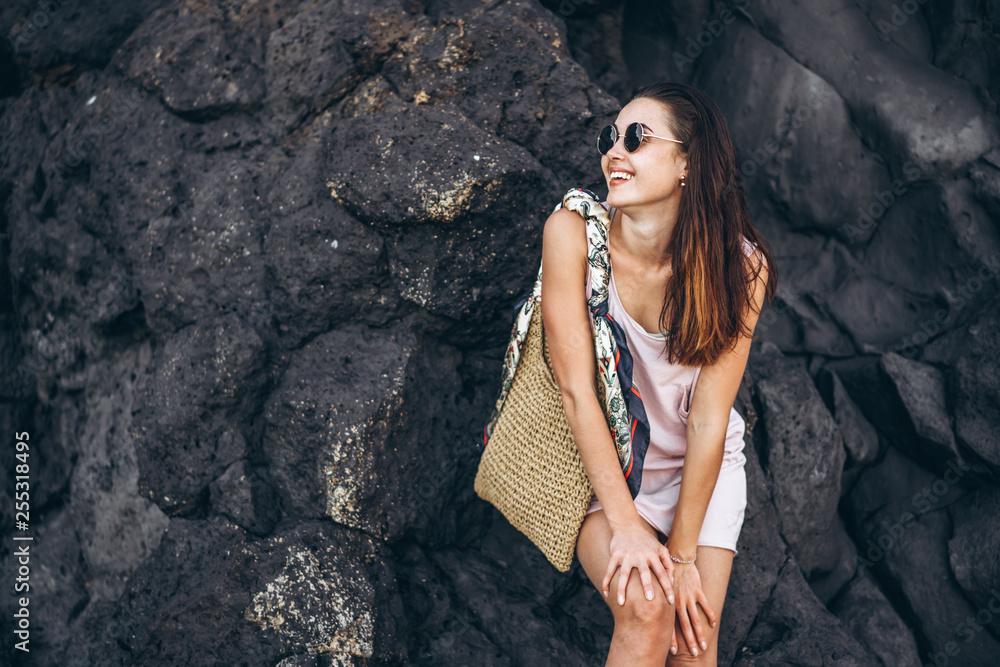 Pretty long hair brunette tourist girl relaxing on the stones near sea. Pretty long hair brunette tourist girl relaxing on the stones near sea.