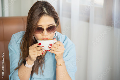 Portrait happy young Asian lady in coffee shop - woman in relax time concept