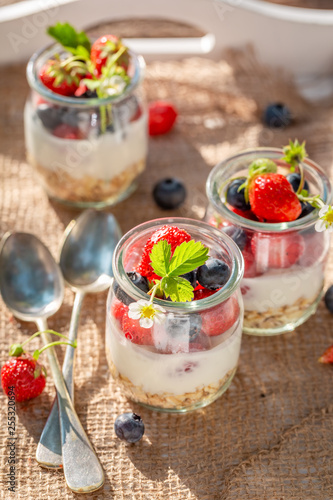 Delicious oat flakes in jar with yoghurt and berries