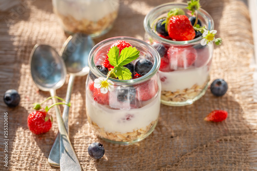 Healthy oat flakes with berries and yoghurt in jar