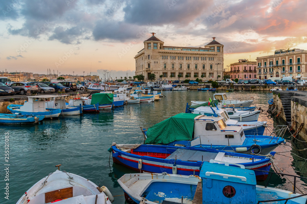 Sea harbour at sunrise with the boats docked in the Ortigia island, Syracuse, Sicily, Italy